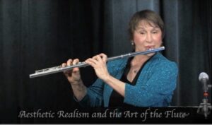 Photo of Barbara Allen, Aesthetic Realism Consultant, playing flute in presentation